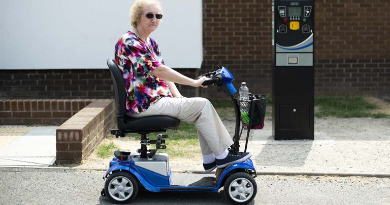 Señora mayor paseando en scooter eléctrico azul